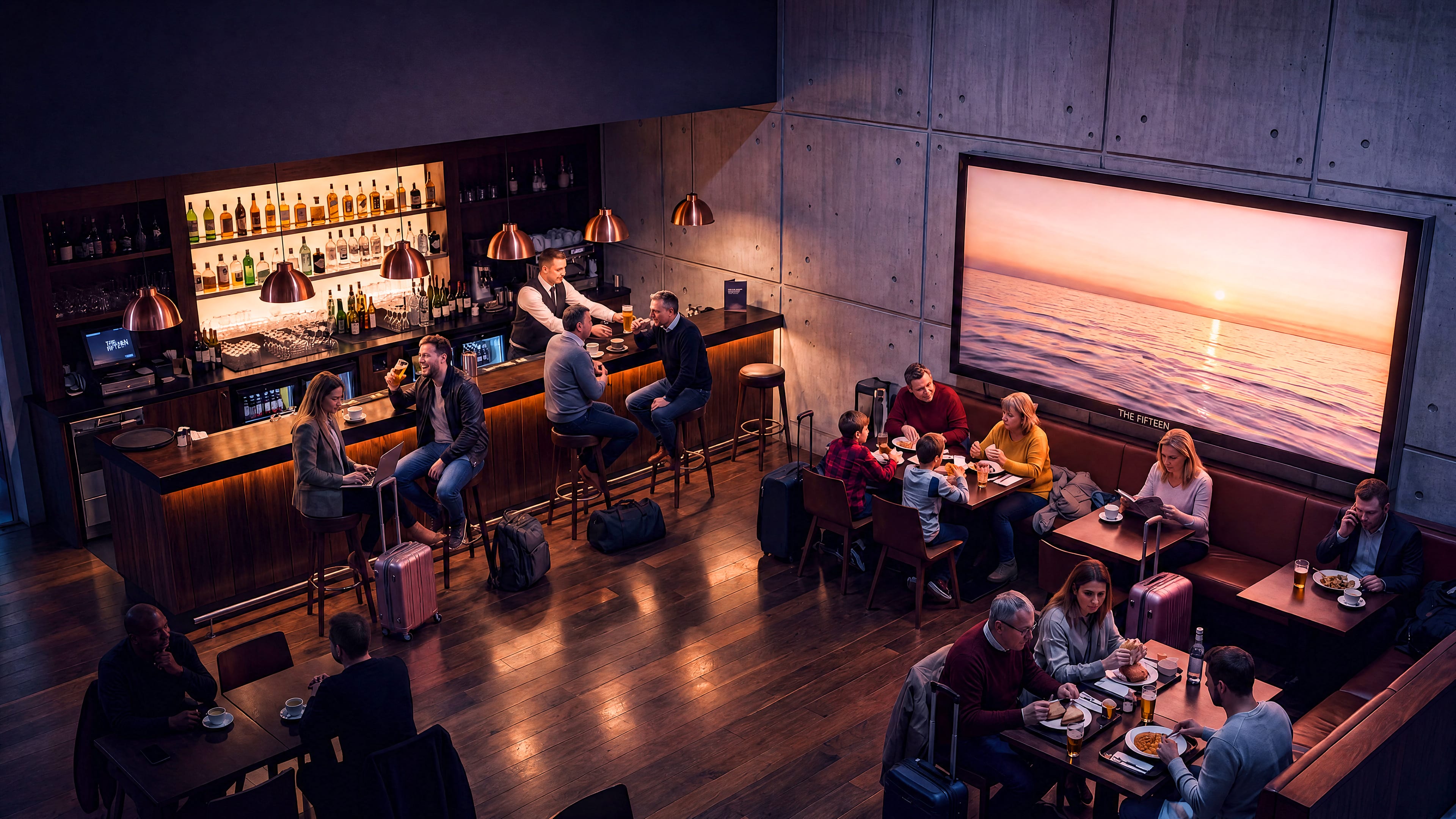 An airport bar full of people reading menus and phones beneath a large lit seascape advertisement in the top corner.