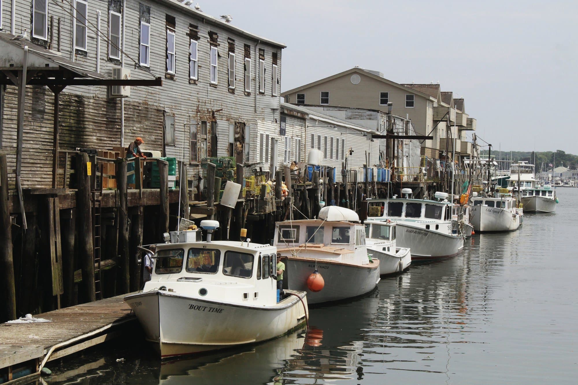 Fishing boats moored in a small harbor town